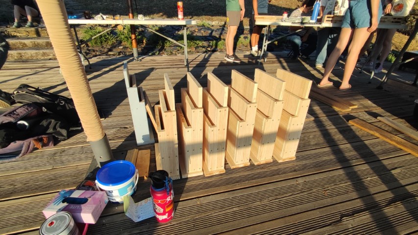 Fila de cajas nido terminadas pendiente del recubrimiento exterior Varias cajas nido de murcielagos colocadas en fila